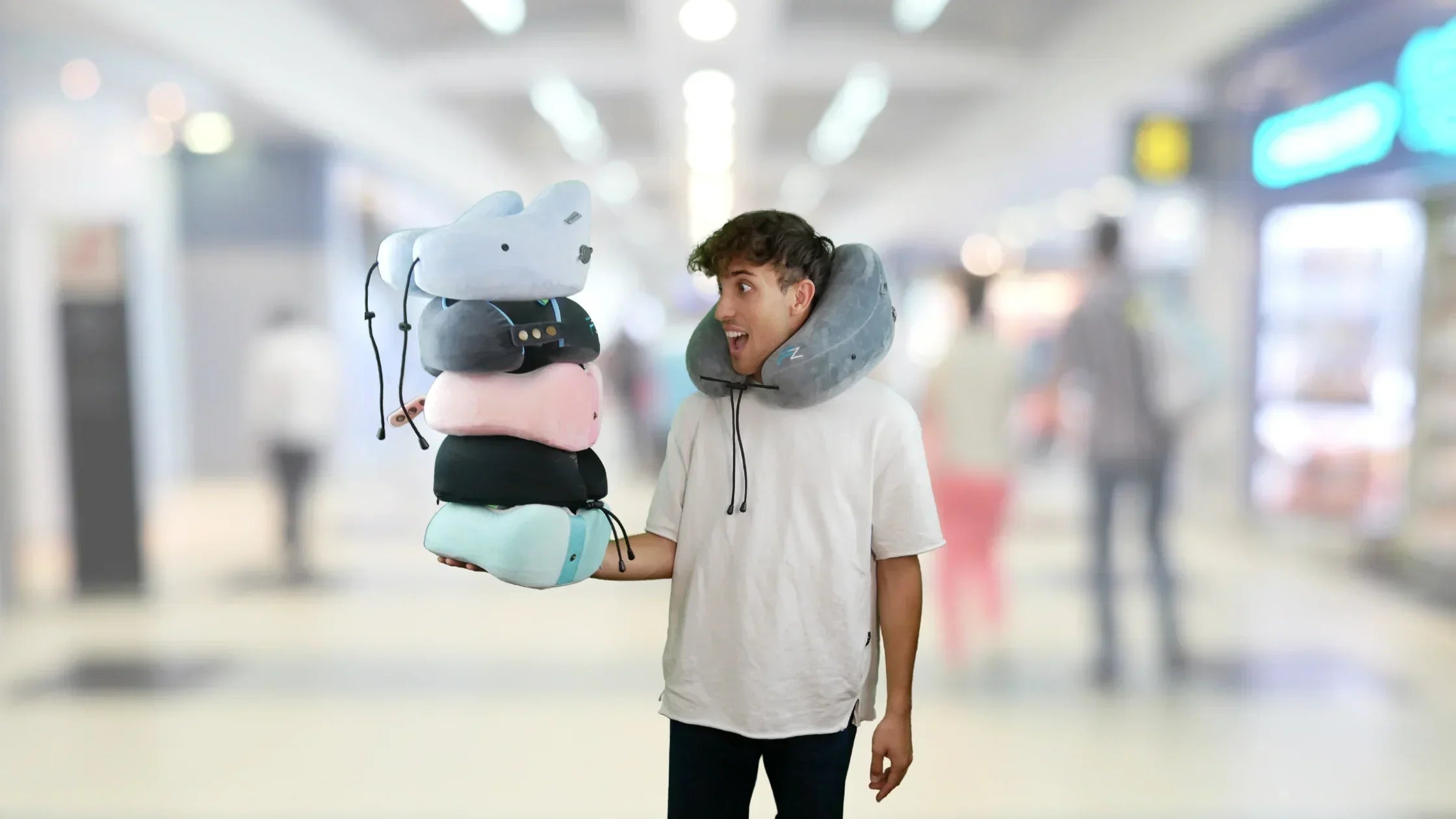 A man wearing one flowzoom airpillow and holding four more towering on his hand