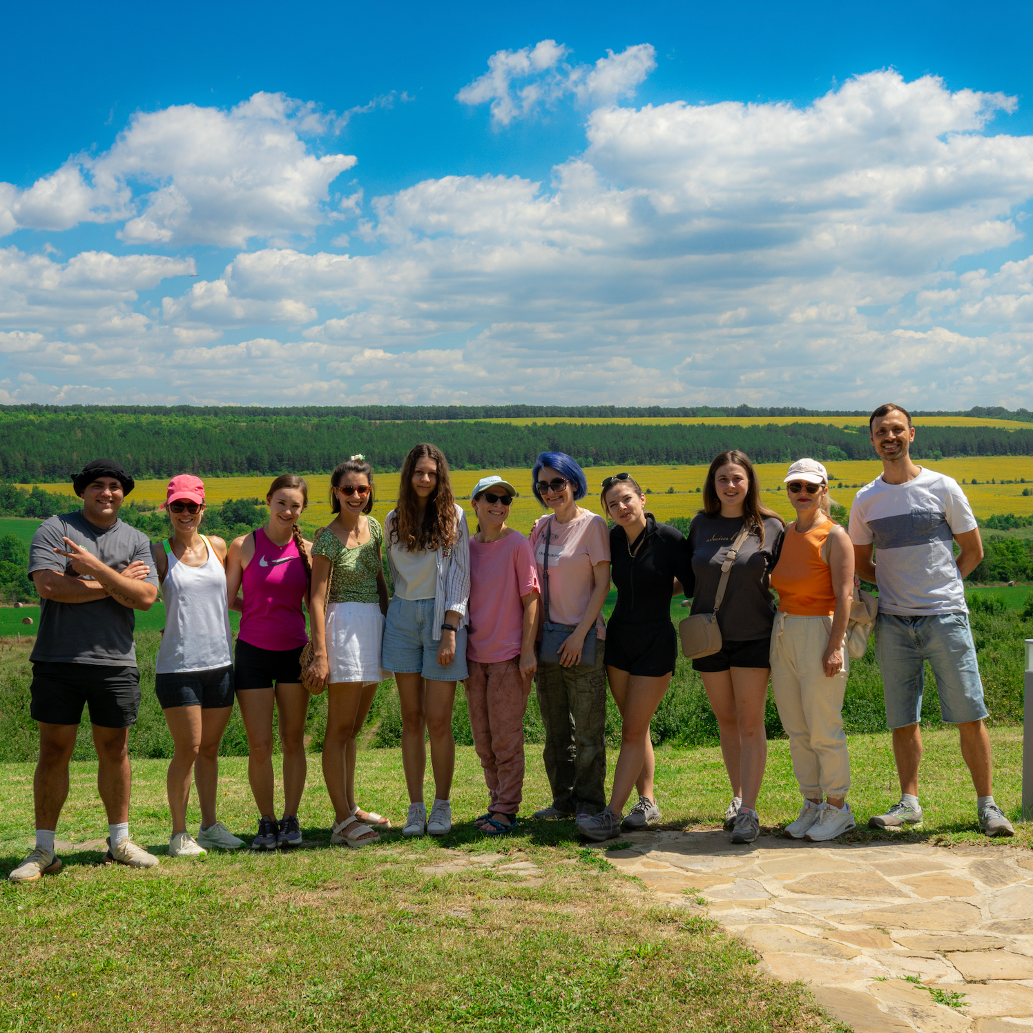 Team Flowzoom posing for a photo in a scenic outdoor setting with green fields and blue sky.